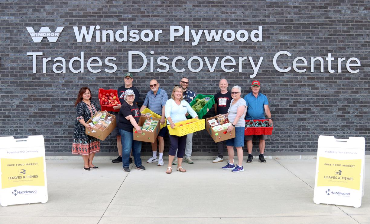 A group of people holding boxes of food outside VIU's Trades Discovery Centre