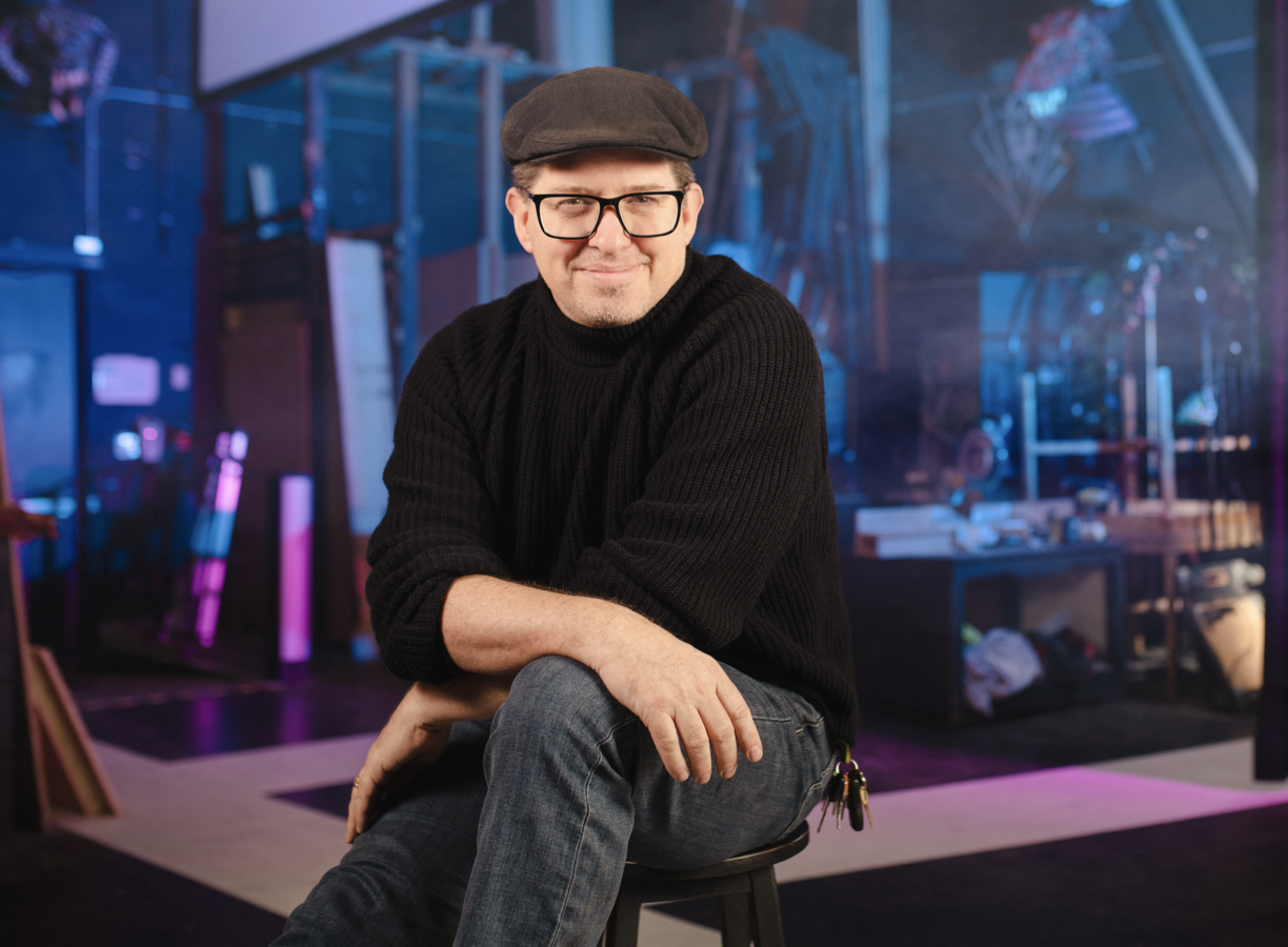 Leon Potter sitting on the stage and smiling at the camera.