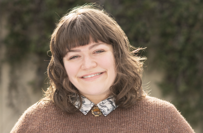Anna Irwin-Borg smiling at the camera outside in a sunny day