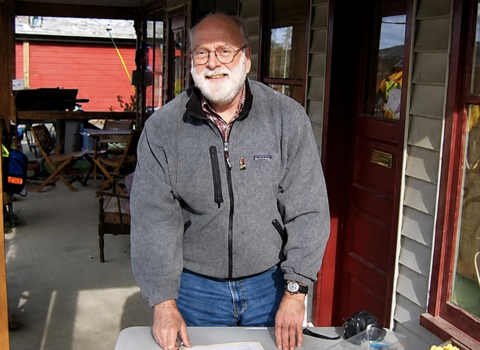 Dave Macmurchie standing at a table outside a building in the sunshine