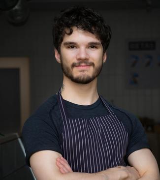 A young man wearing an apron