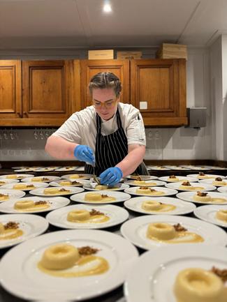 A professional baker preparing plates of dessert