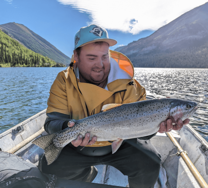 Nick holds a fish in a boat