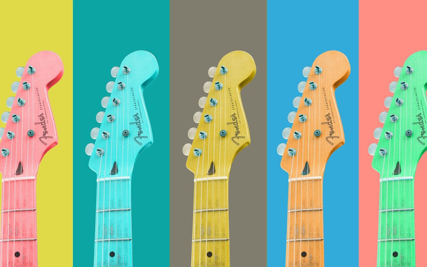 The top half of guitars pictured against yellow, green, grey, blue and peach backgrounds.