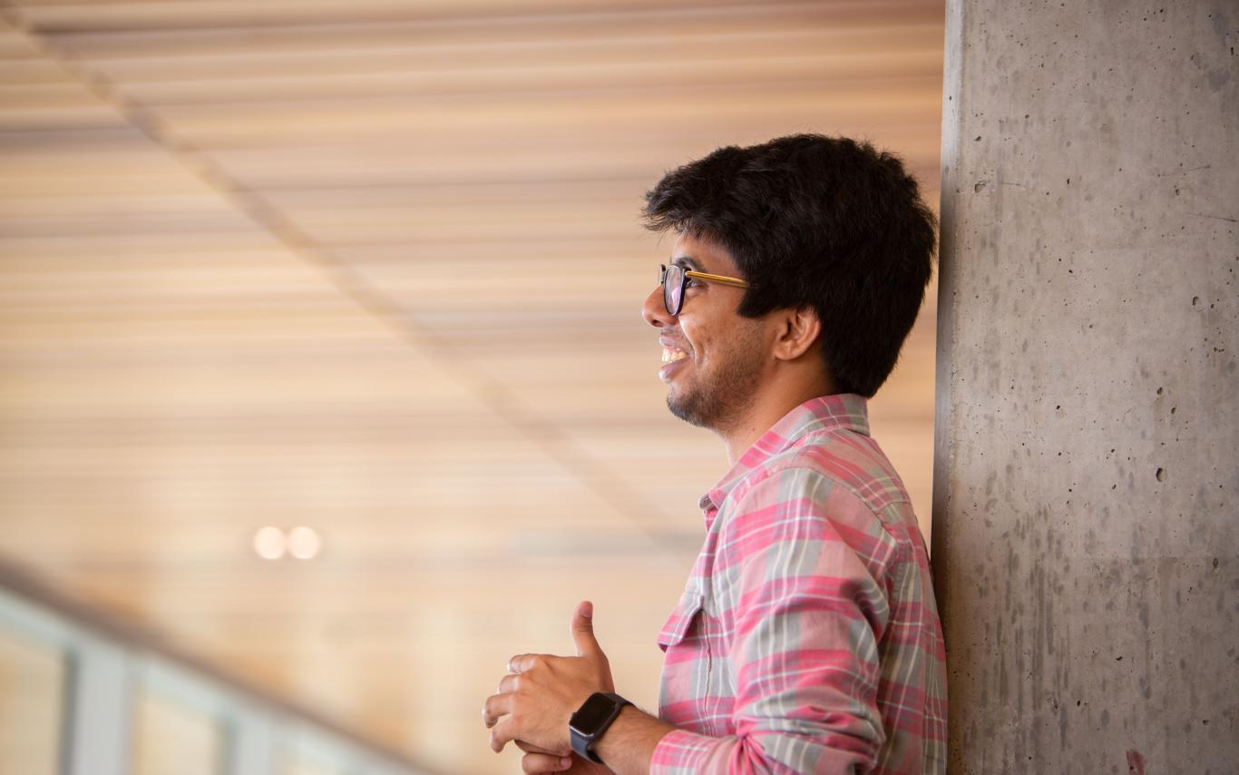Student leaning against a pole