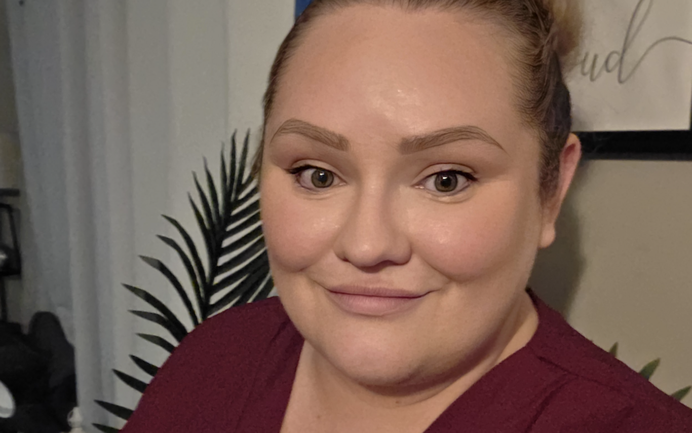 Kylie smiling at the camera wearing a red shirt.
