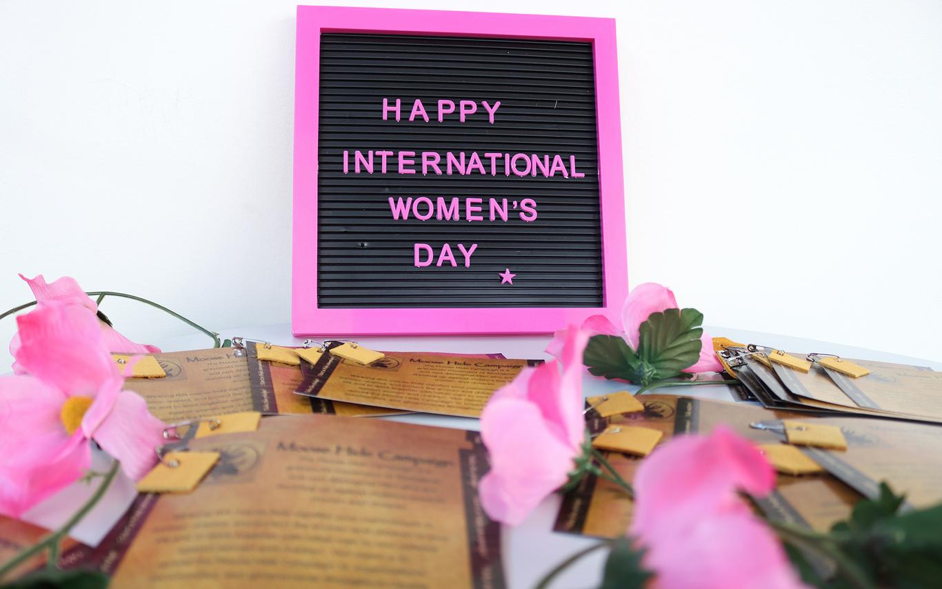 A small sign with a pink border that reads Happy International Women's Day