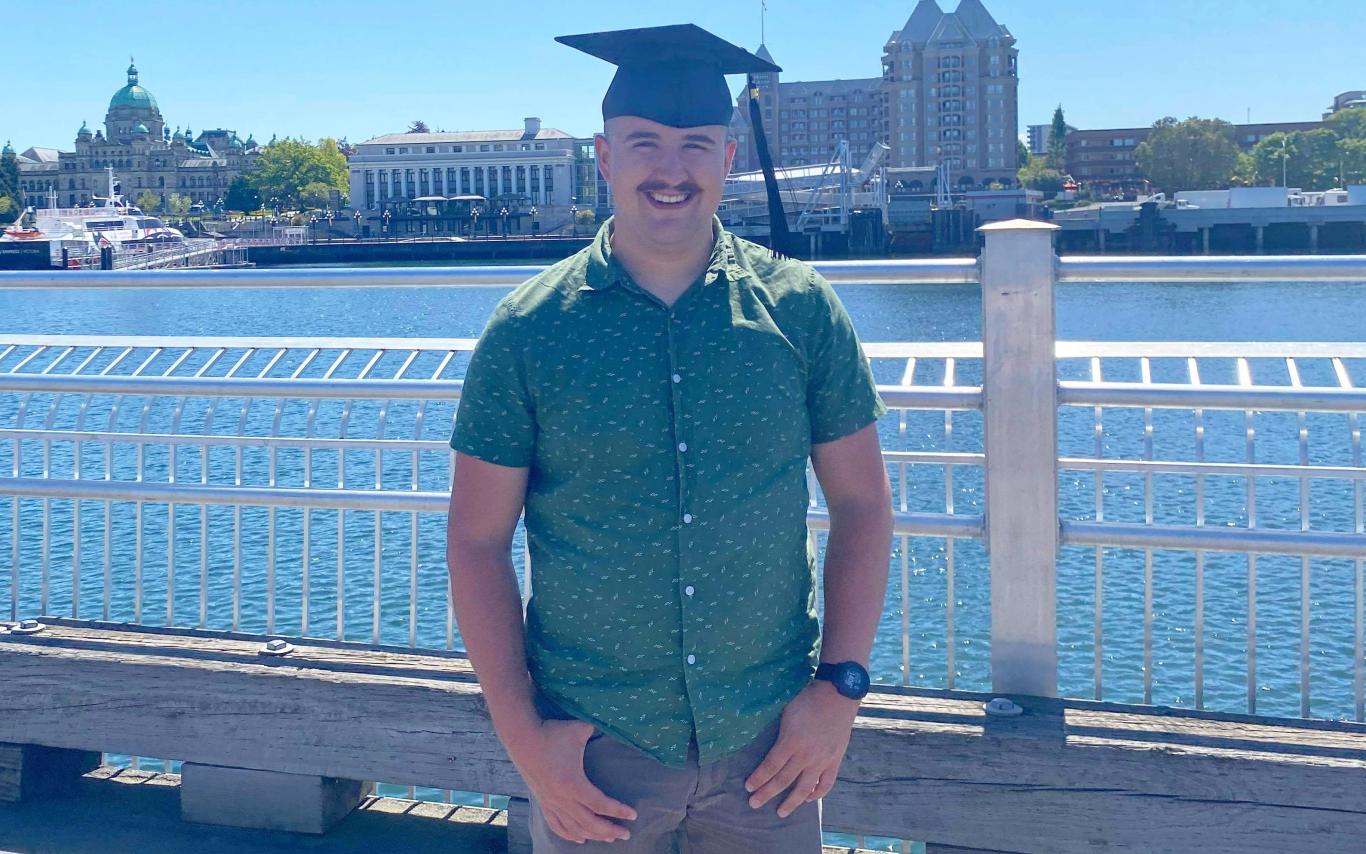 VIU Criminology grad Liam Kenney posing in his grad hat