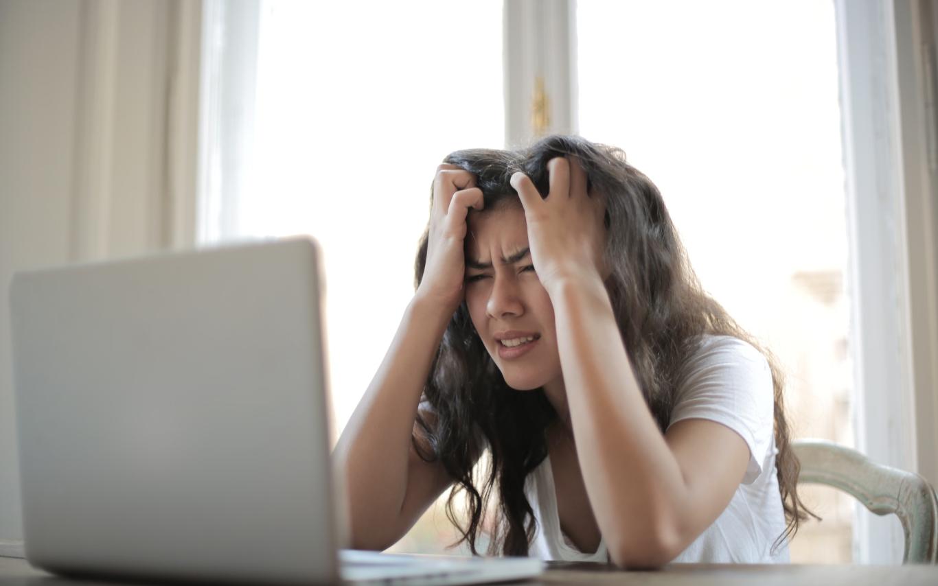Girl staring at a computer screen with head in hands