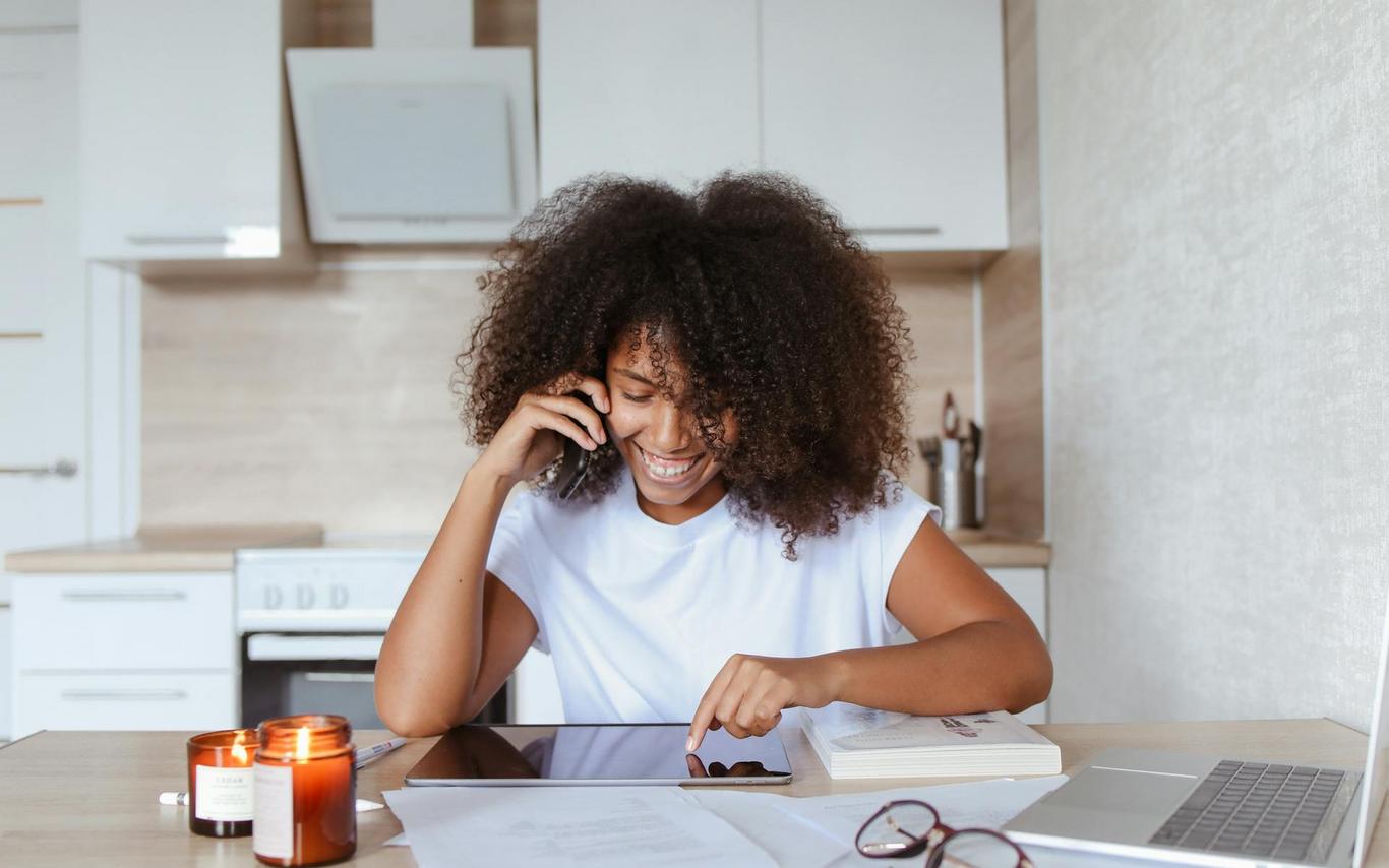 A woman looks at a tablet while sitting at a table