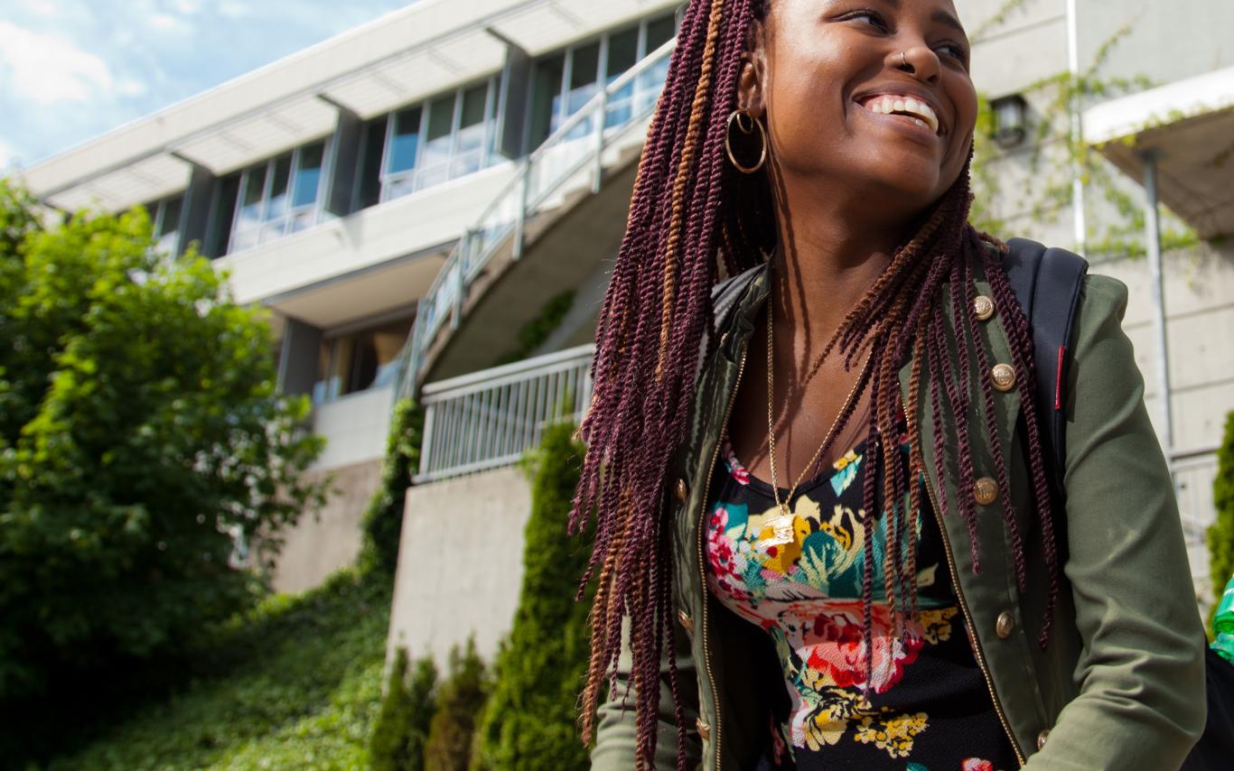 student smiling outside of library
