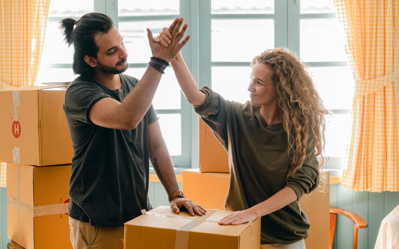 Students high fiving over moving boxes