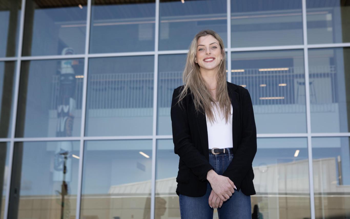 Teagan stands outside the glass windows on the Centre for Health and Science at VIU's Nanaimo campus