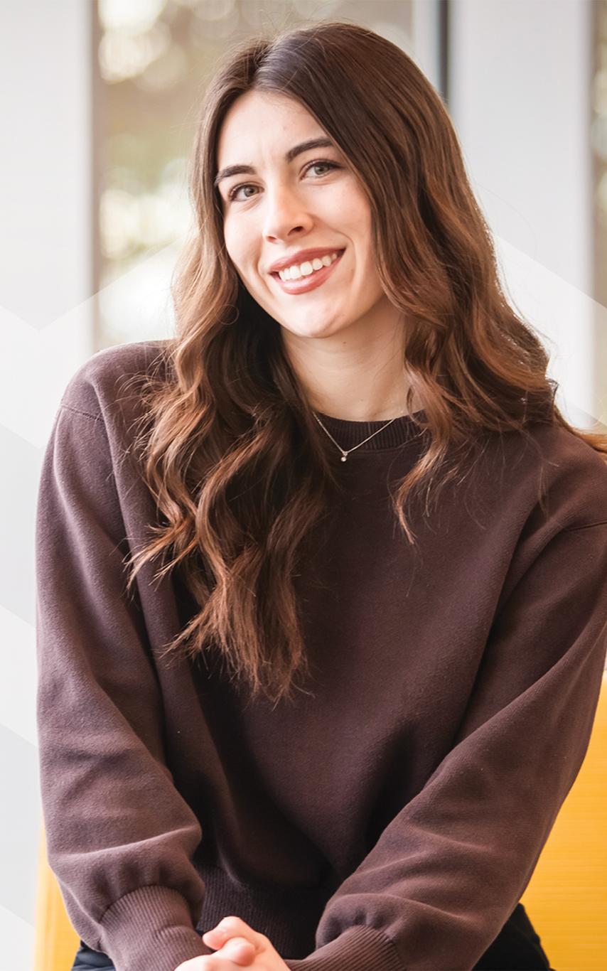 Smiling young woman in front of a window