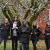 Five women hold Christmas lights at Milner Gardens with a ladder behind them