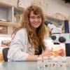 Genevieve van der Voort examines insect samples with a microscope.