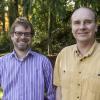 Dr. Erik Krogn and Dr. Chris Gill stand beside each other in a wooded area