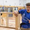 Two carpentry students work on a project